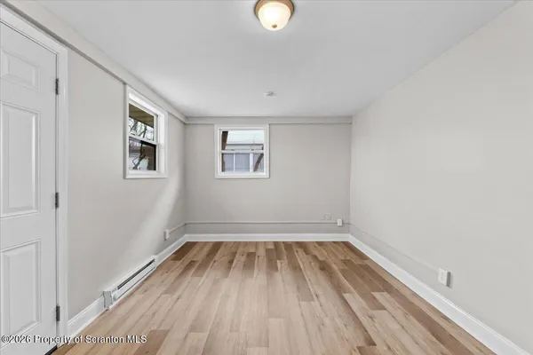 a view of empty room with wooden floor