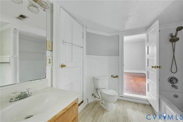 an empty room with wooden floor and ceiling fan