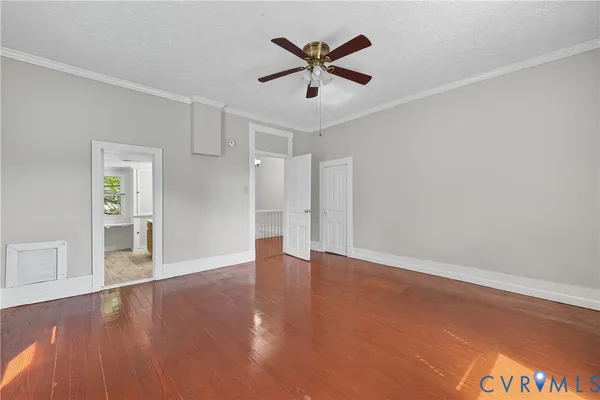 an empty room with wooden floor and ceiling fan