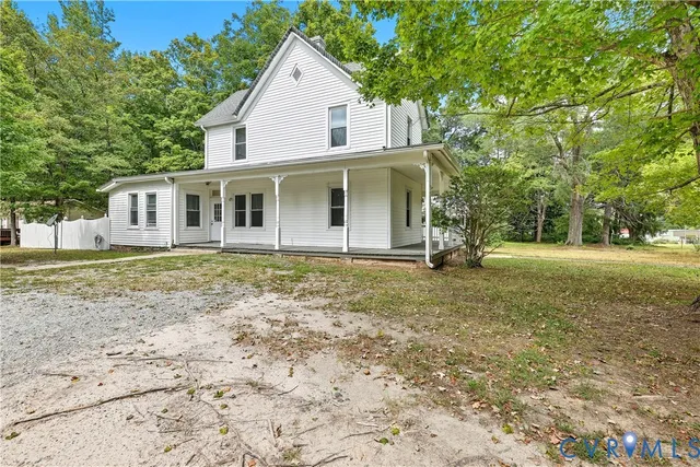 a view of a house with backyard and trees