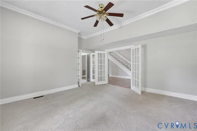 an empty room with chandelier fan