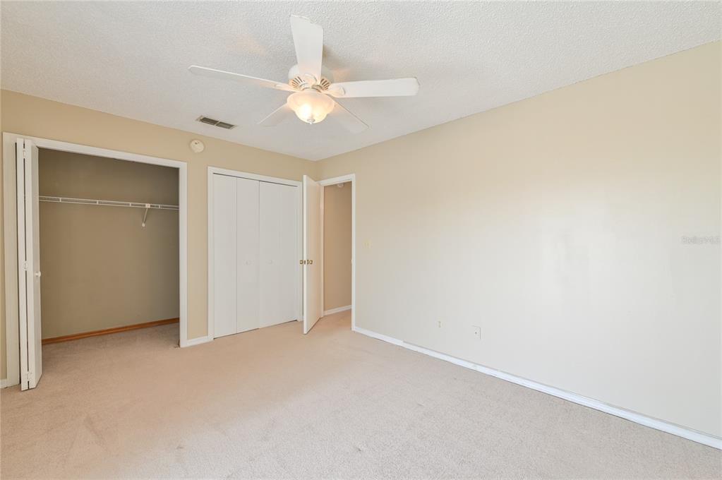 11001 Southeast Sunset Harbor Road, Unit H52 Summerfield, FL 34491 - Photo 12 of 31 an empty room with a chandelier fan and closet area