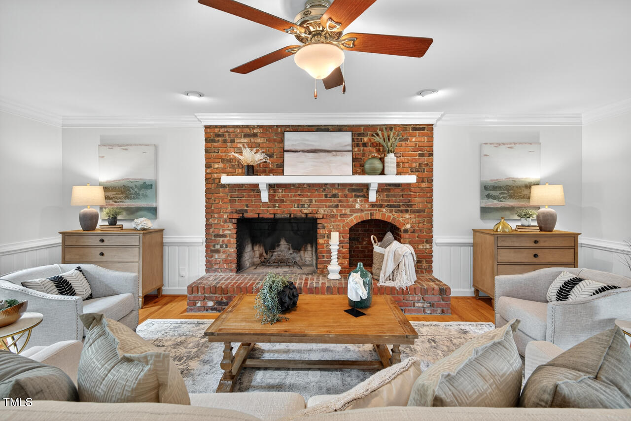 2805 Dunkirk Drive Raleigh, NC 27613 - Photo 9 of 36 a living room with furniture a fireplace and a chandelier