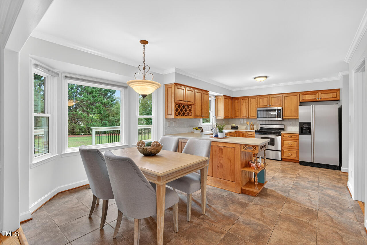 2805 Dunkirk Drive Raleigh, NC 27613 - Photo 12 of 36 a dining room with furniture a chandelier and kitchen view