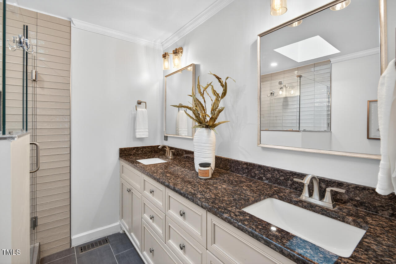 2805 Dunkirk Drive Raleigh, NC 27613 - Photo 19 of 36 a bathroom with a granite countertop sink and a mirror