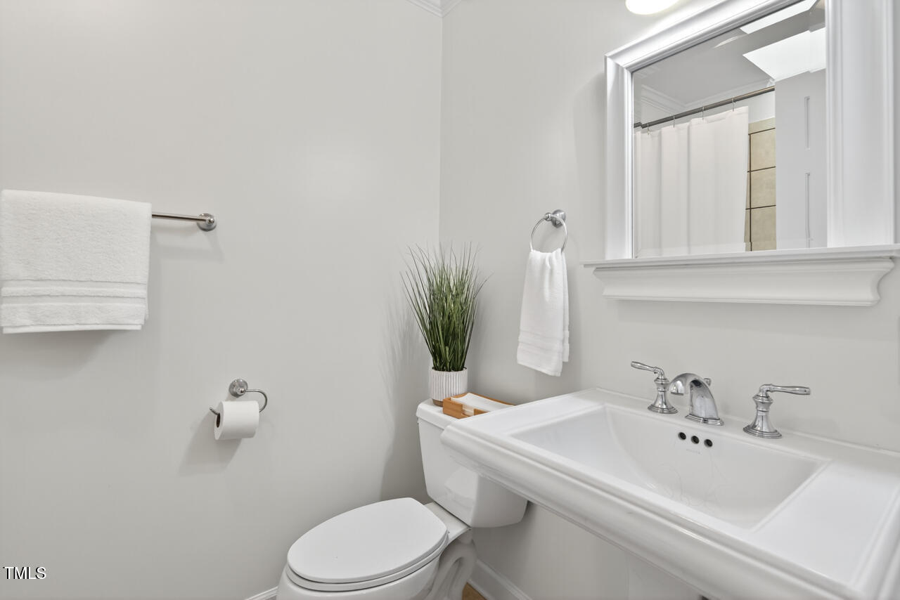 2805 Dunkirk Drive Raleigh, NC 27613 - Photo 24 of 36 a bathroom with a sink a toilet and mirror