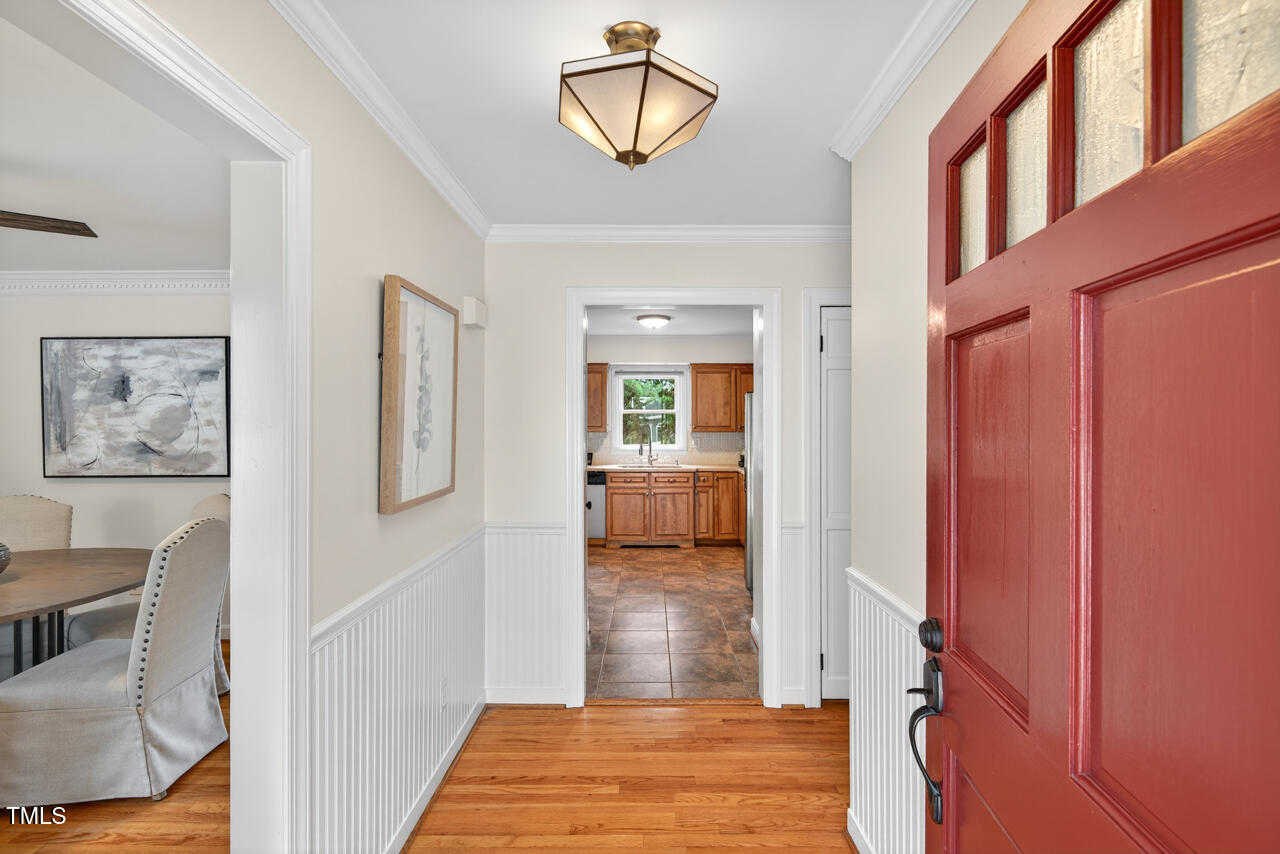 2805 Dunkirk Drive Raleigh, NC 27613 - Photo 3 of 36 a view of a hallway with wooden floor and a dining room