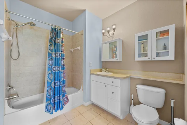 a living room with furniture a flat screen tv and a floor to ceiling window