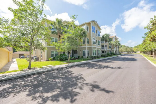 a view of a backyard with wooden fence and large trees