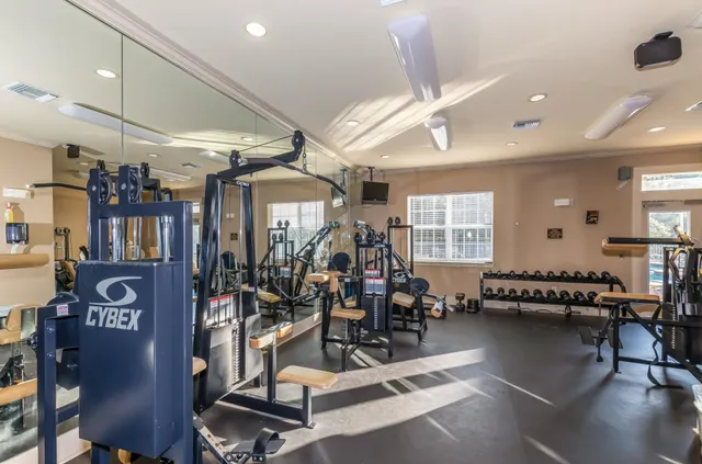 a front view of multi story residential apartment building with yard and green space