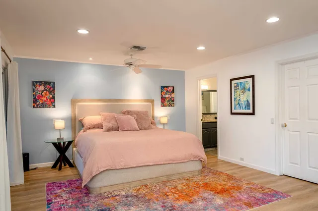a bedroom with a large bed and a wooden floor