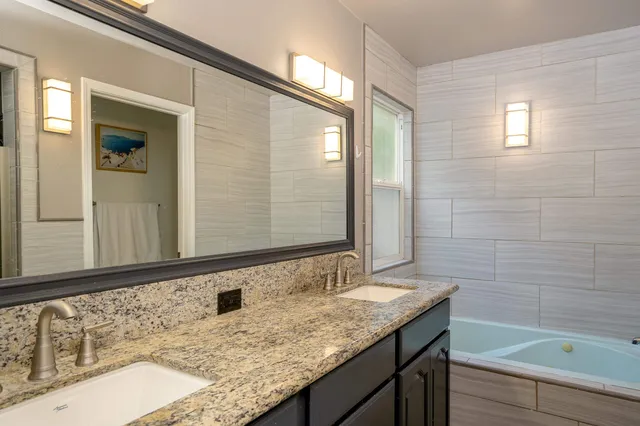 a bathroom with a granite countertop sink and a mirror