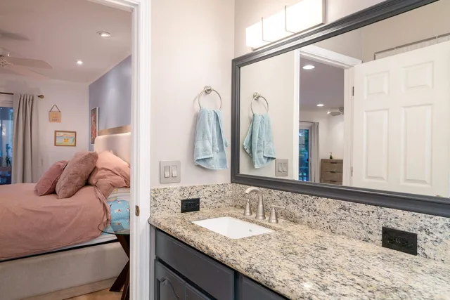 a bathroom with a granite countertop sink and a mirror