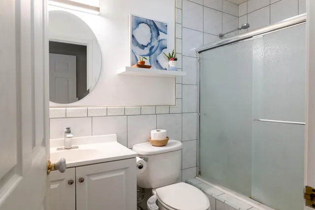 a bathroom with a sink a toilet and shower