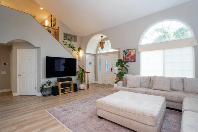 a living room with furniture a flat screen tv and a large window