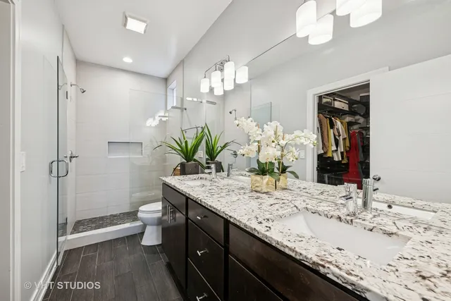 a bathroom with a granite countertop sink a toilet and a large mirror