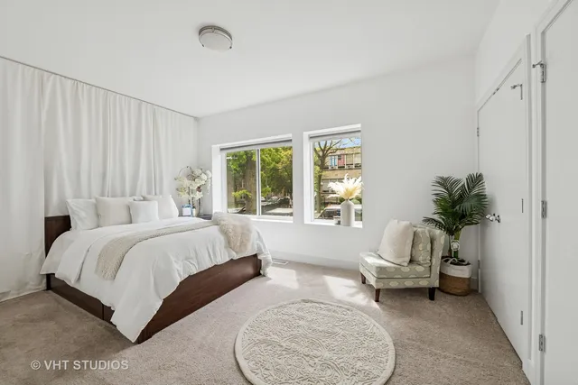 a spacious bedroom with a bed a couch and potted plant
