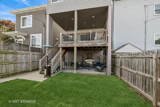 a view of a chair and tables in the back yard of the house