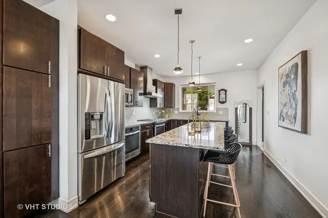 a kitchen with stainless steel appliances granite countertop a refrigerator a oven a sink a stove and a refrigerator