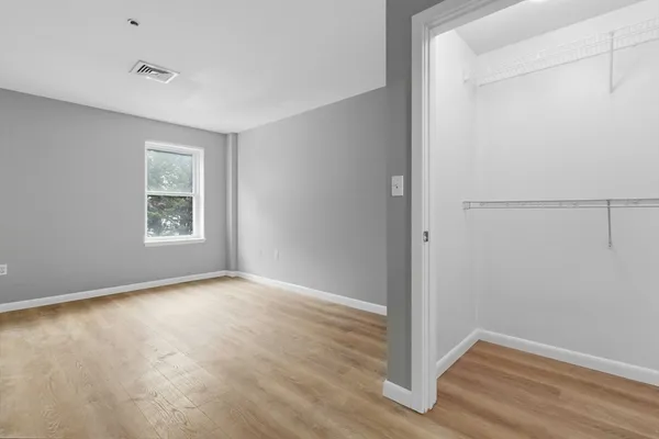 an empty room with windows and closet