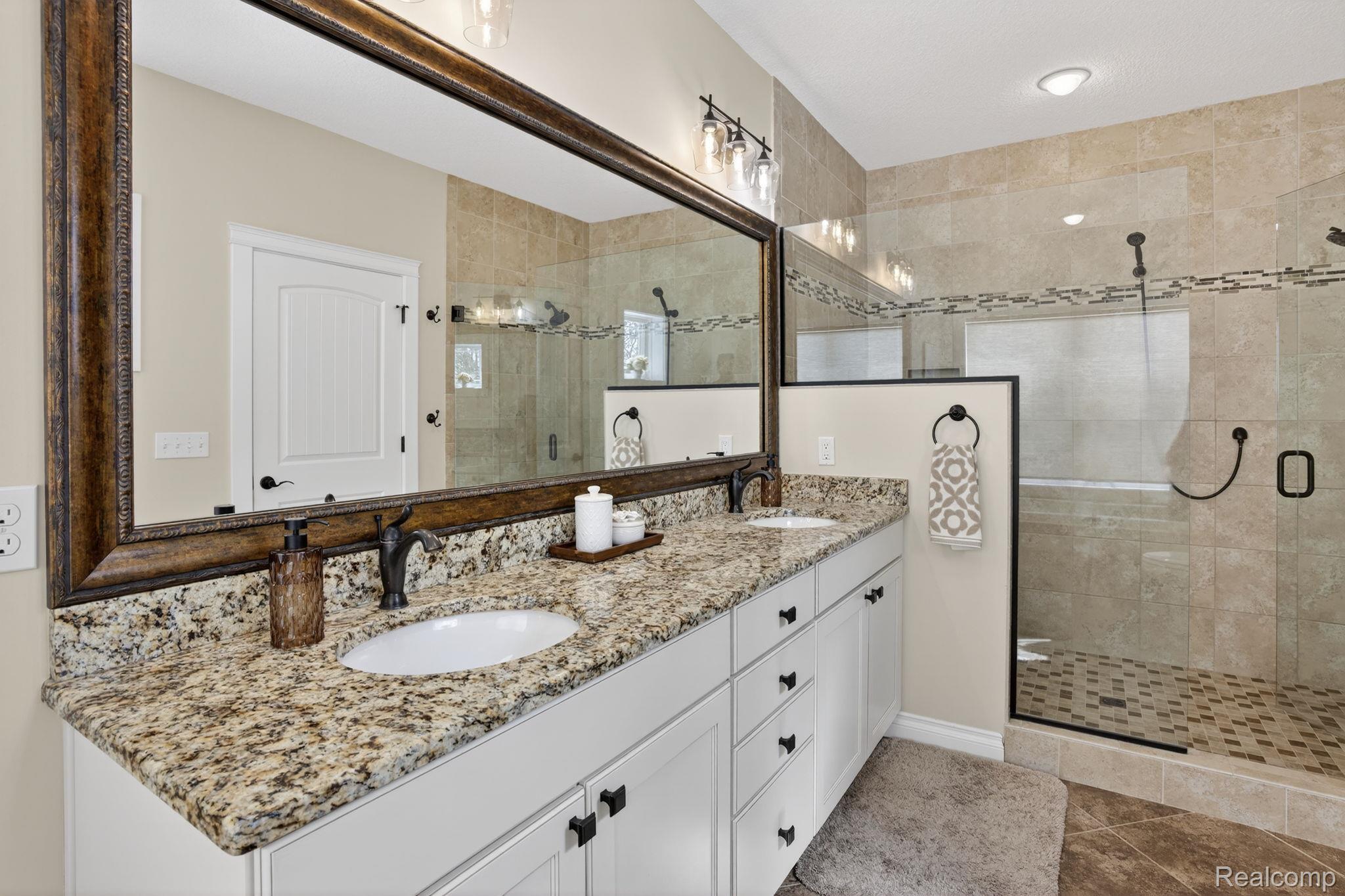 101 Highview Road Traverse City, MI 49696 - Photo 42 of 88 Full bathroom featuring double vanity and a shower stall