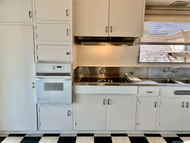 a kitchen with granite countertop white cabinets and a stove