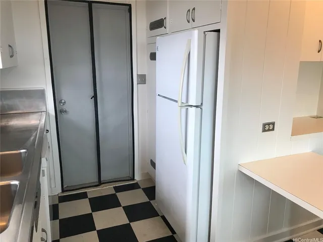 a view of a refrigerator in kitchen and a sink