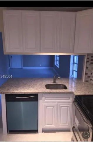 a kitchen with granite countertop a sink and a stove