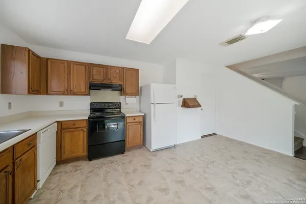 a kitchen with a refrigerator and a stove top oven
