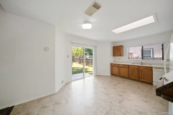 a large white kitchen with stainless steel appliances a large window