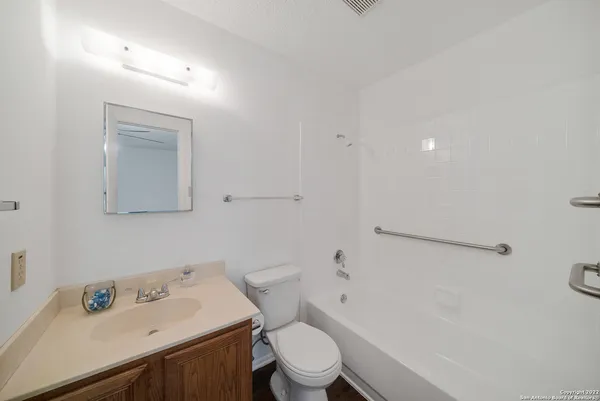 a bathroom with a sink mirror vanity and toilet