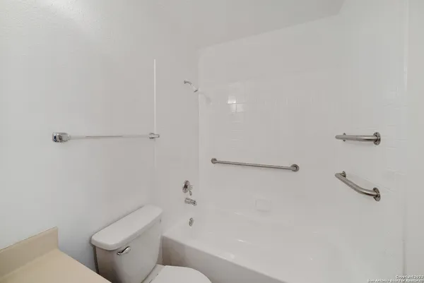 a white toilet sitting next to a bath tub