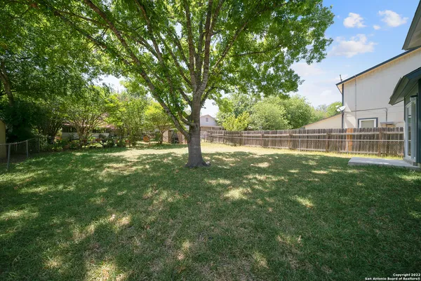 a view of green field with trees in the background