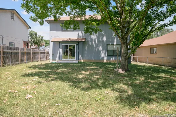 a front view of house with yard and trees around