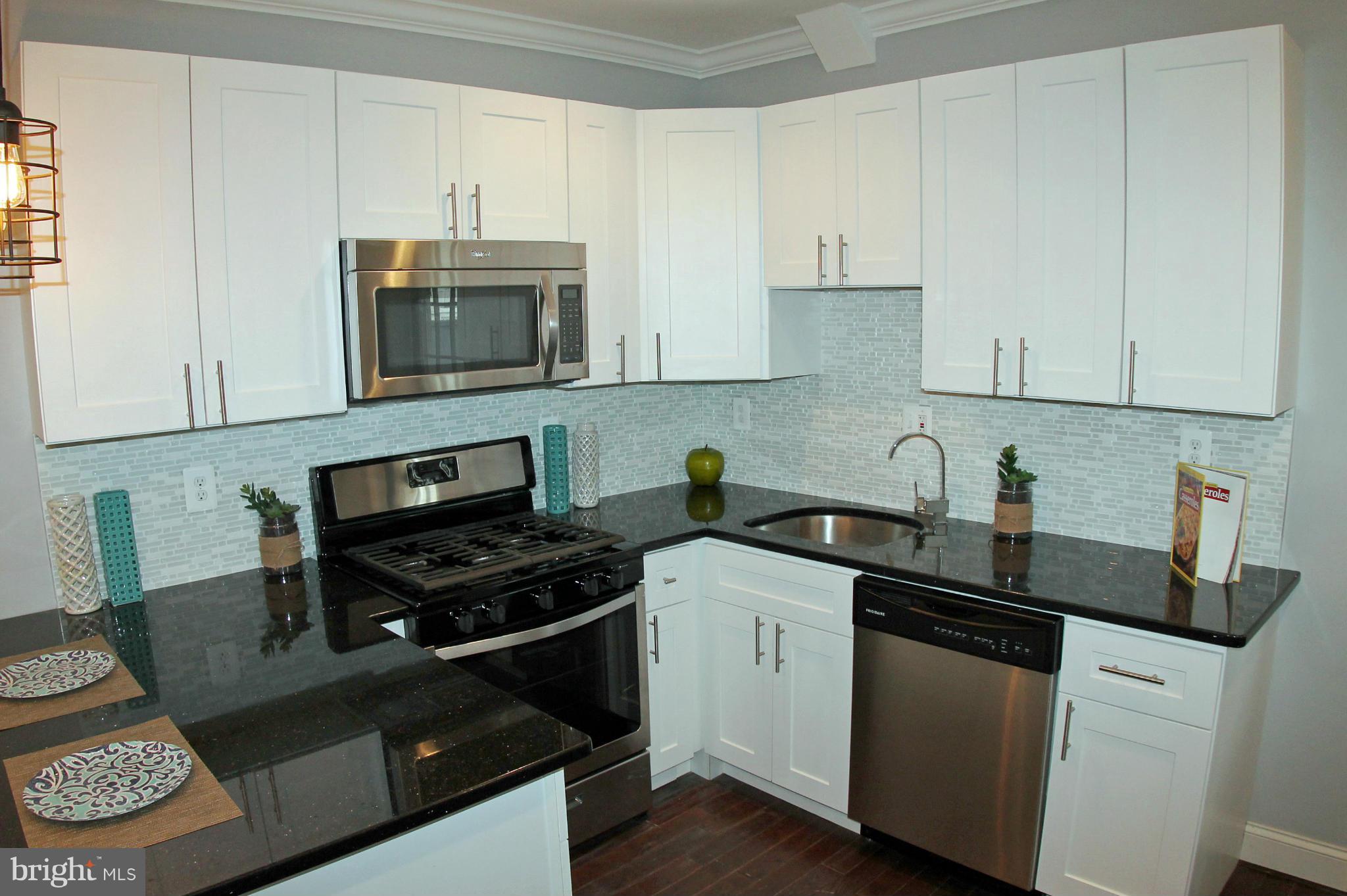 5510 Tramore Road Baltimore, MD 21214 - Photo 11 of 30 a kitchen with stainless steel appliances granite countertop a sink stove and cabinets