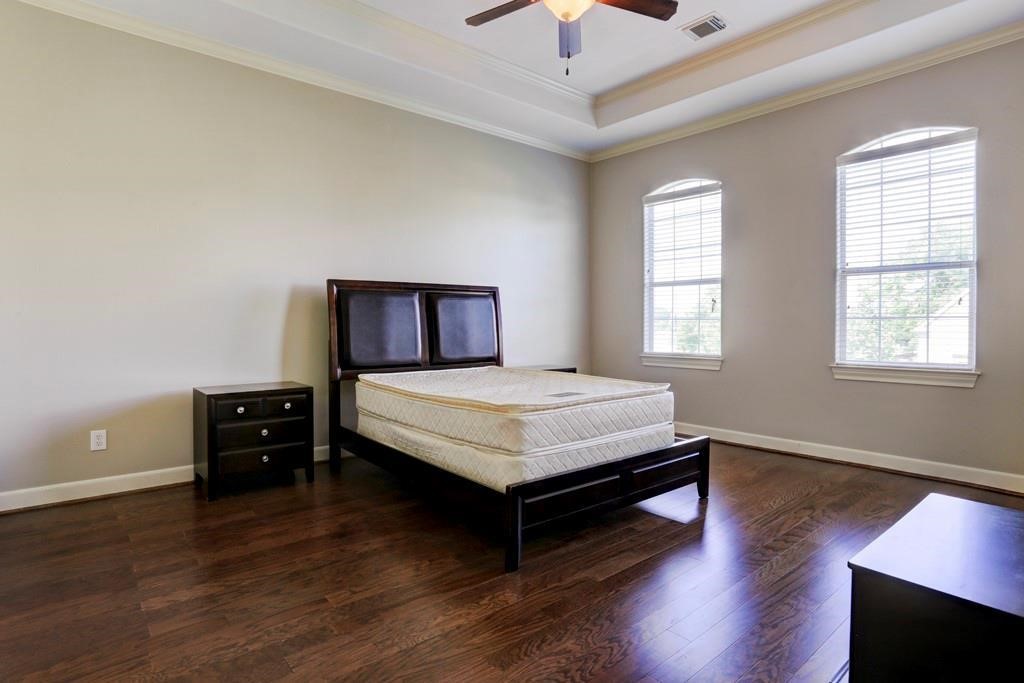 923 Birdsall Street Houston, TX 77007 - Photo 10 of 21 a bedroom with a bed and wooden floor