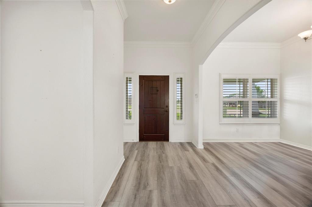 528 Hubbard Circle Nevada, TX 75173 - Photo 12 of 36 Entryway with arched walkways, light wood finished floors, ornamental molding, and baseboards