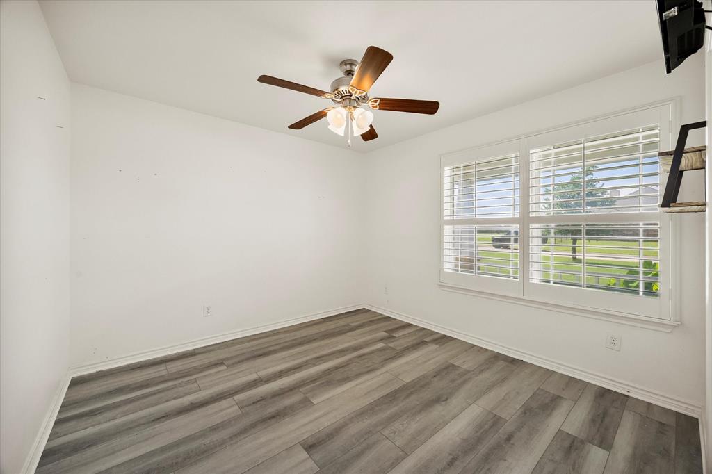 528 Hubbard Circle Nevada, TX 75173 - Photo 26 of 36 Unfurnished room with wood finished floors, a ceiling fan, and baseboards