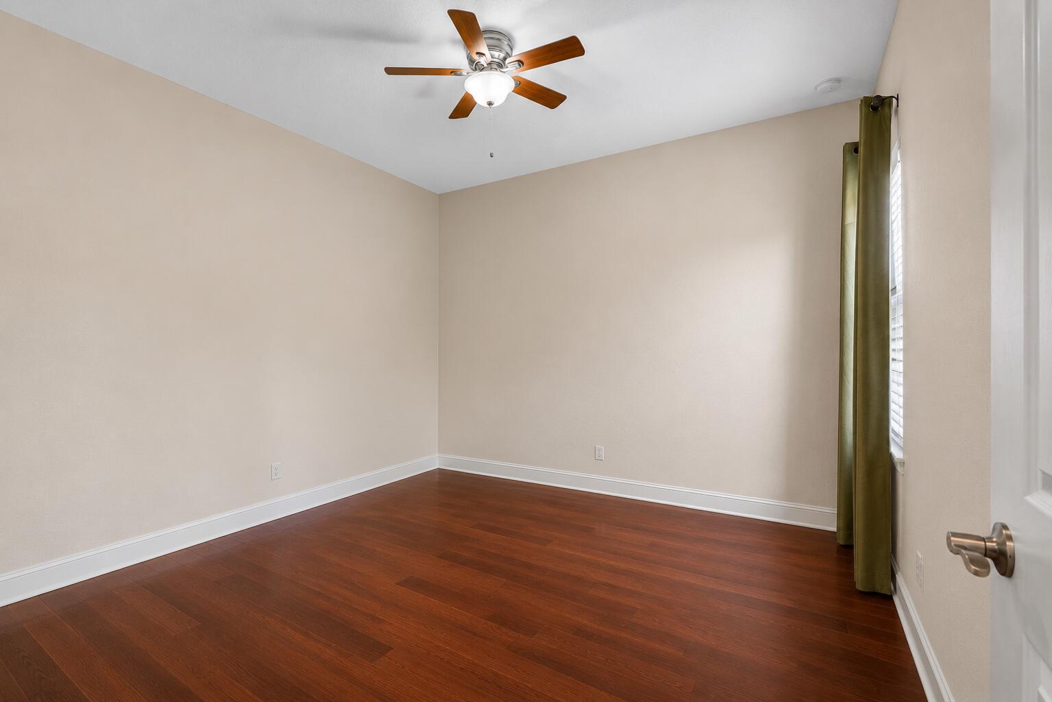 16610 Gateway Bridge Drive Delray Beach, FL 33446 - Photo 21 of 67 an empty room with wooden floor a ceiling fan and windows