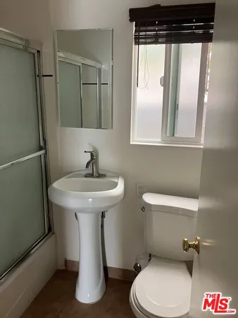 a bathroom with a toilet a sink and a mirror