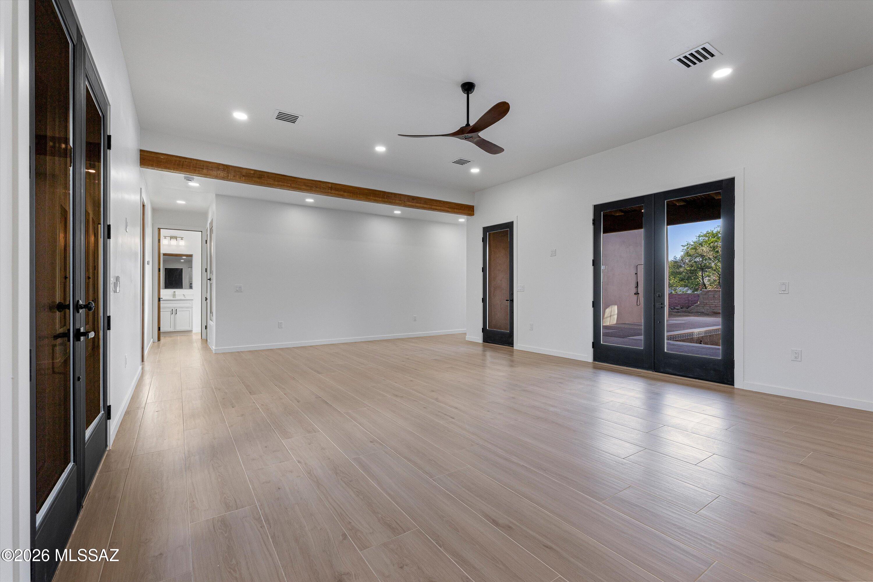 5259 East Fort Lowell Road Tucson, AZ 85712 - Photo 9 of 50 a view of an empty room with wooden floor and a ceiling fan