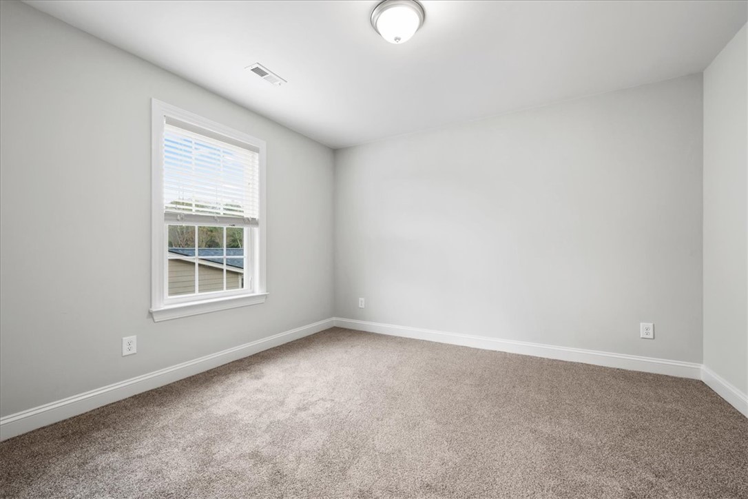 102 Ripplestone Way Anderson, SC 29621 - Photo 24 of 39 A well-lit bedroom features plush carpeting, creating a comfortable and inviting atmosphere.