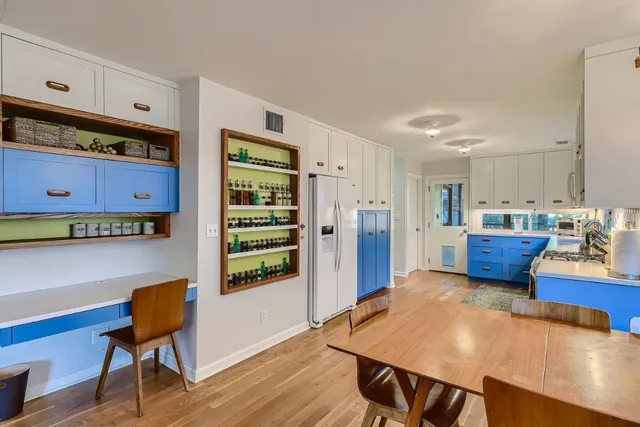 a kitchen with stainless steel appliances dining table chairs and wooden floor
