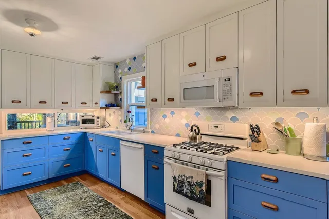 a kitchen with stainless steel appliances granite countertop a sink a stove and cabinets