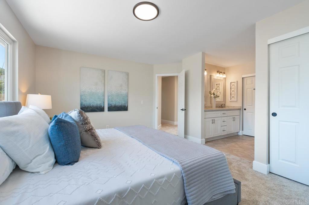 536 Heather Ridge Road San Marcos, CA 92078 - Photo 40 of 66 a spacious bedroom with a bed and a lamp