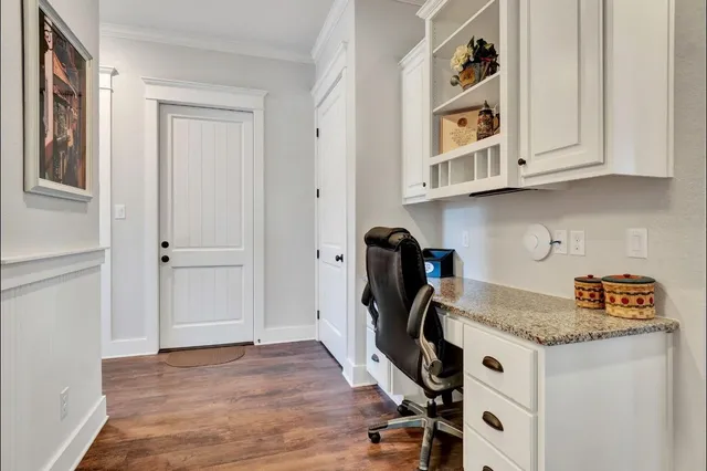 a view of a kitchen with granite countertop white cabinets and wooden floor
