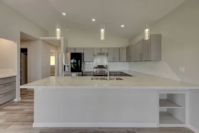 a large kitchen with kitchen island a sink and a stove top oven