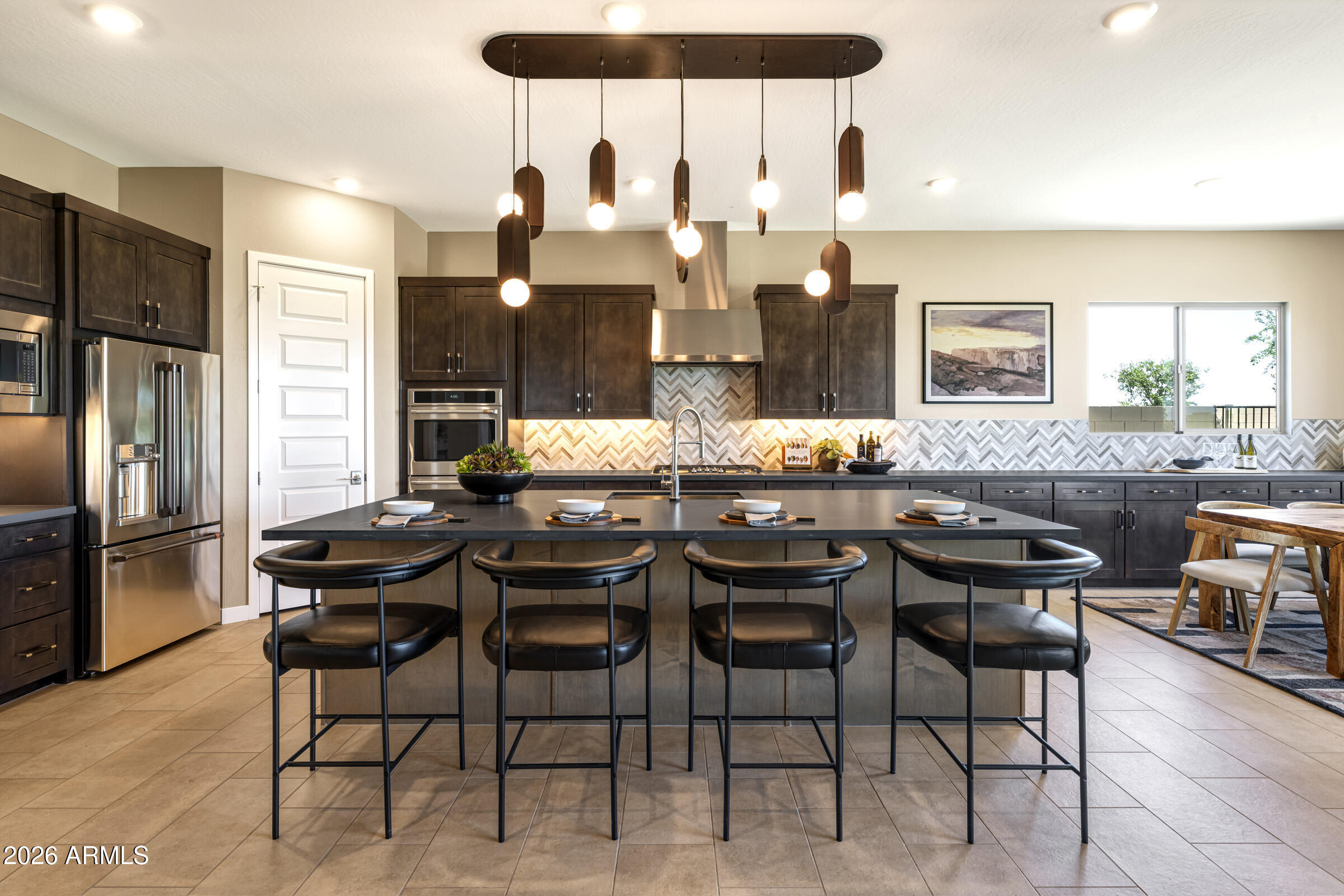 686 West Treasure Trail Apache Junction, AZ 85120 - Photo 3 of 15 a kitchen with stainless steel appliances kitchen island granite countertop a dining table chairs and a refrigerator