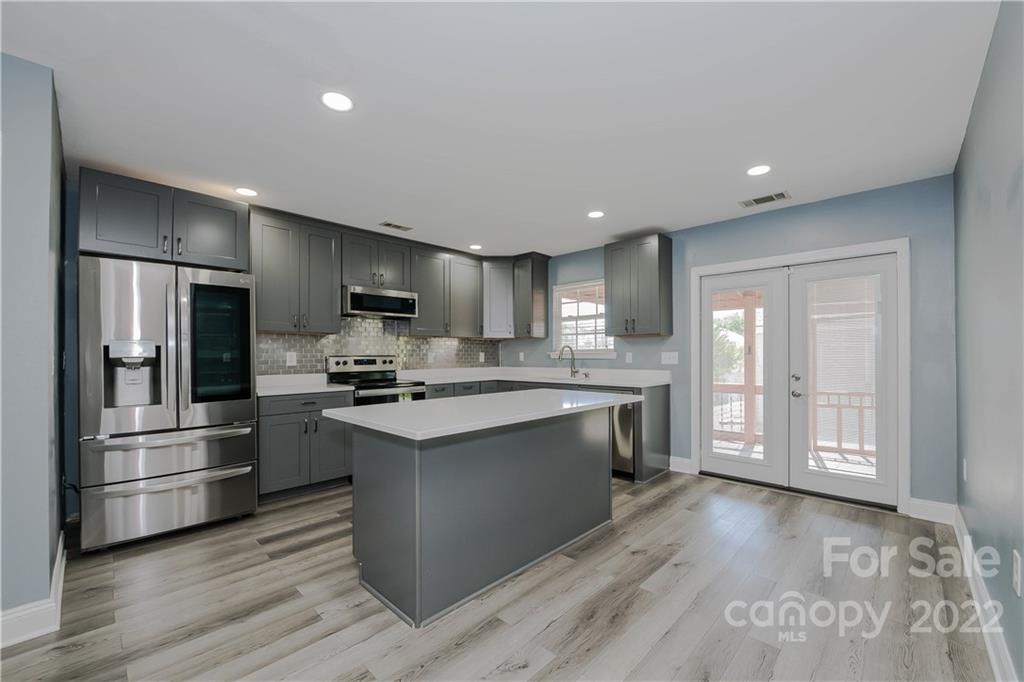 722 Overlook Road Lowell, NC 28098 - Photo 6 of 22 a kitchen with stainless steel appliances granite countertop a stove a refrigerator and a microwave with wooden floors