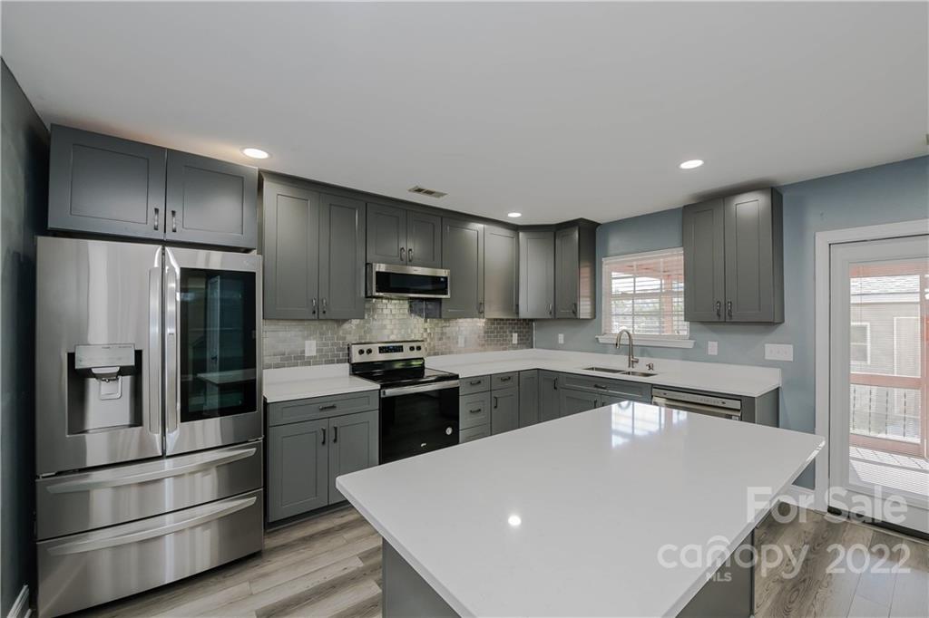 722 Overlook Road Lowell, NC 28098 - Photo 7 of 22 a large kitchen with a large counter top stainless steel appliances and cabinets
